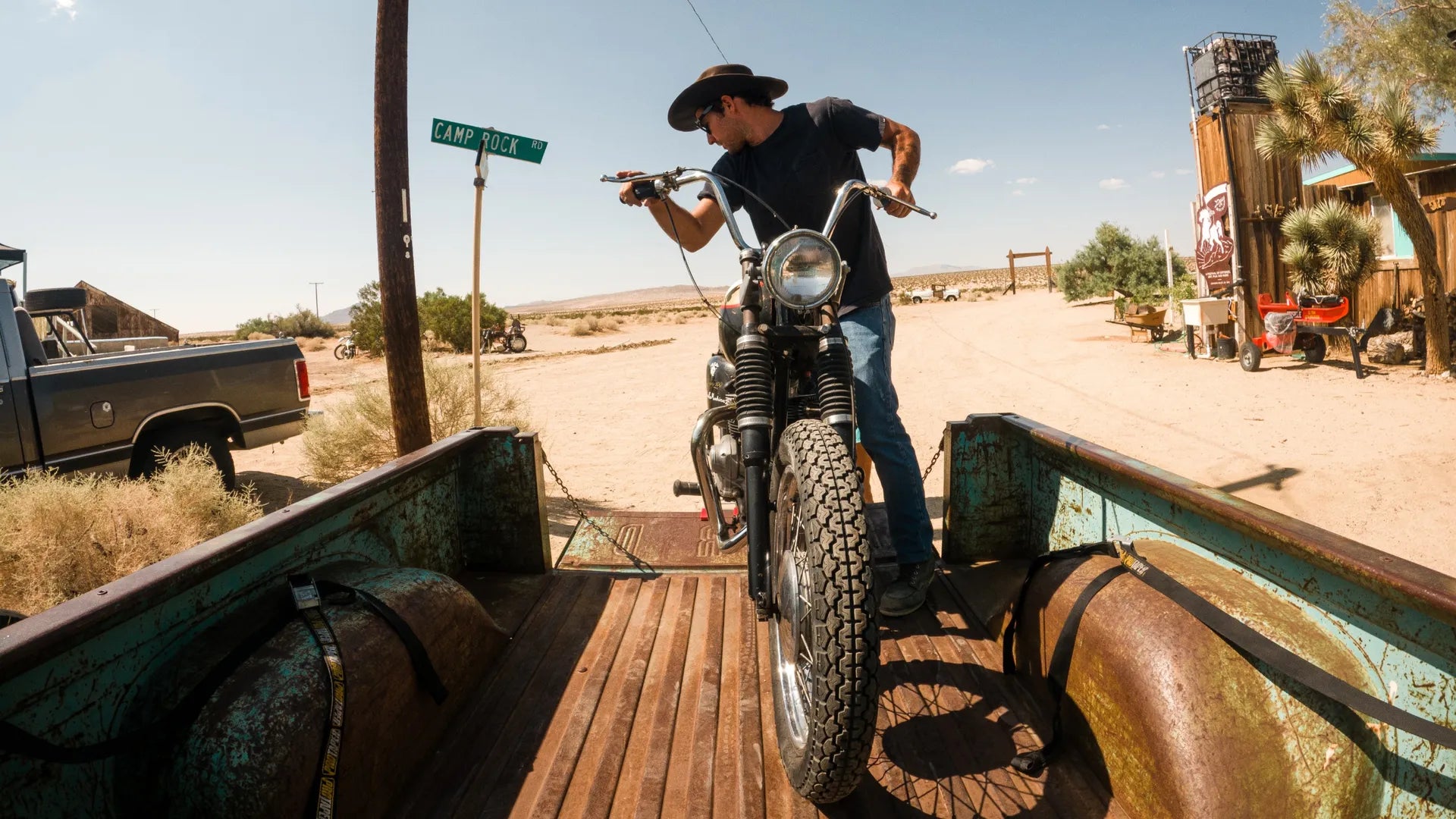 GoPro camera clip attached to a pick up truck with a man loading a retro motorcycle