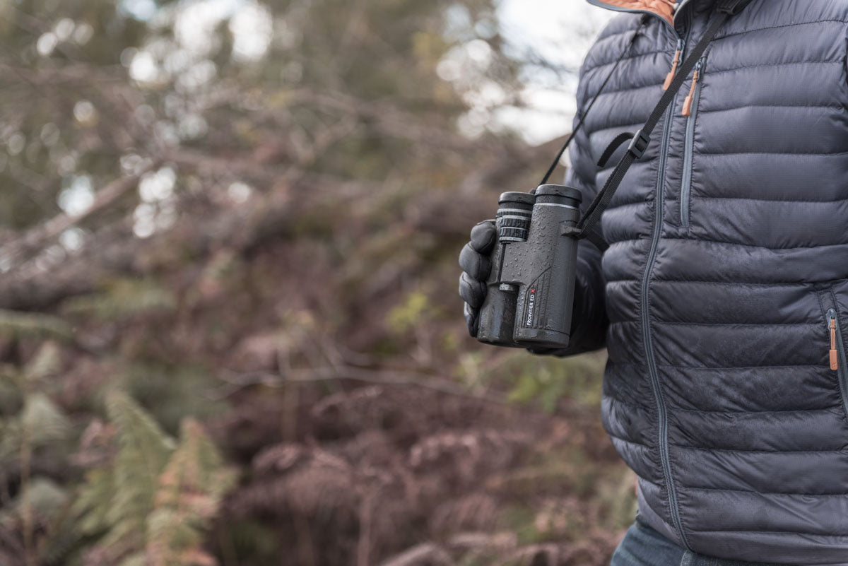 Second lifestyle photo of the binoculars in use by a man in the woodland