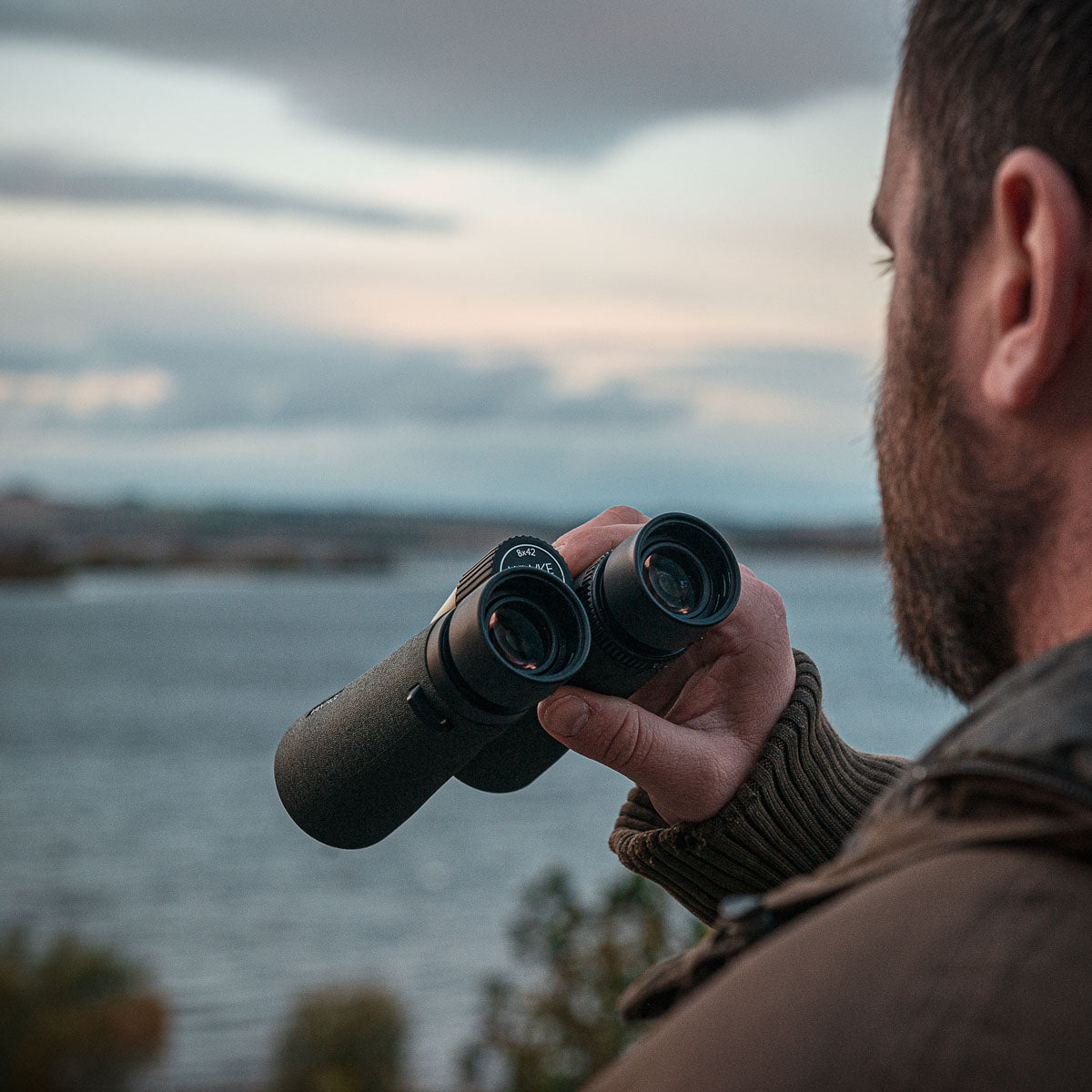 Lifestyle shot of the binoculars being used by the ocean