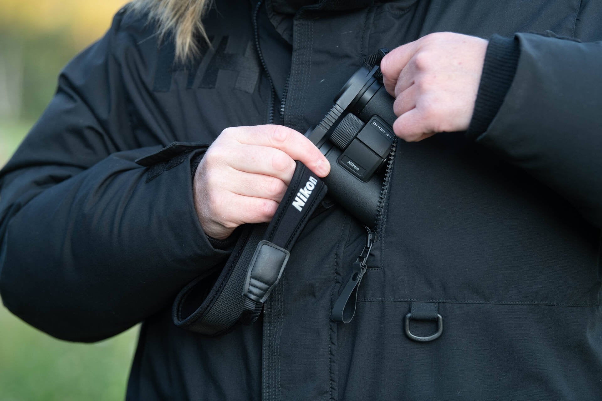 Photo of the binoculars being worn and put away into a jacket