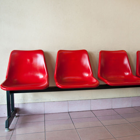 Red-molded-plastic-seats-in-a-row-anchored-on-metal