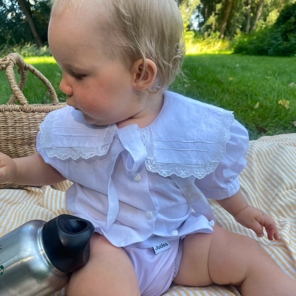 Judes Baby on picnic blanket in the grass with basket and bottle, helpful cloth diapering