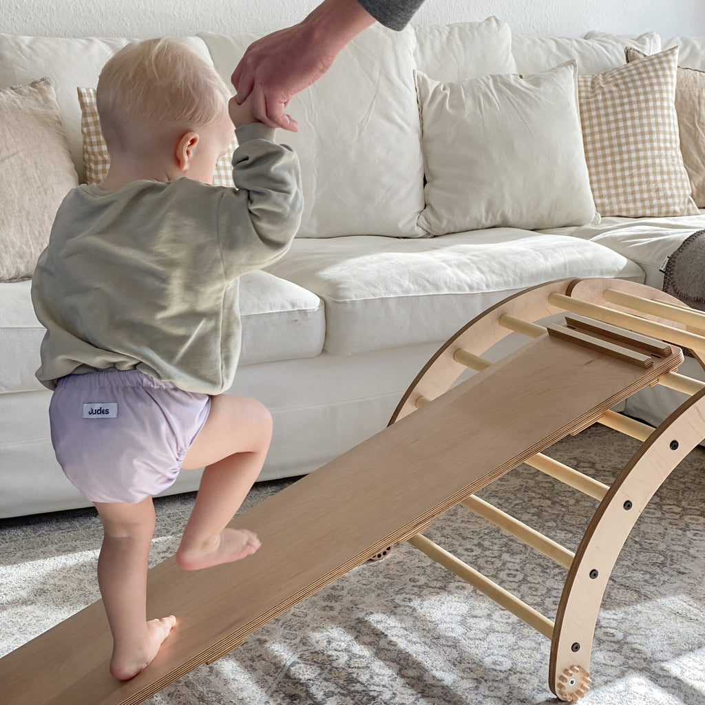 Judes Baby marche sur une rampe en bois dans une maternelle