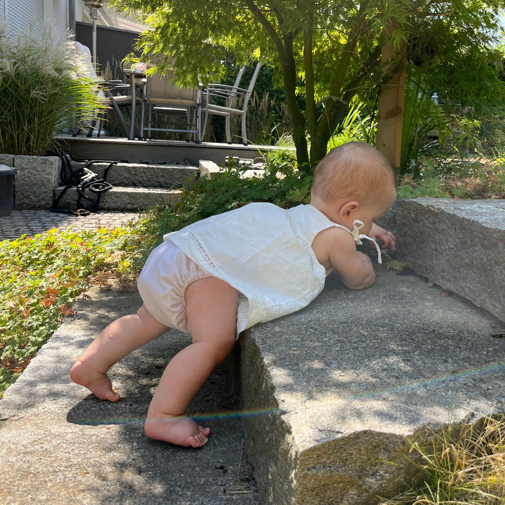 Bébé Judes sur escalier de jardin avec des couches sans substances nocives