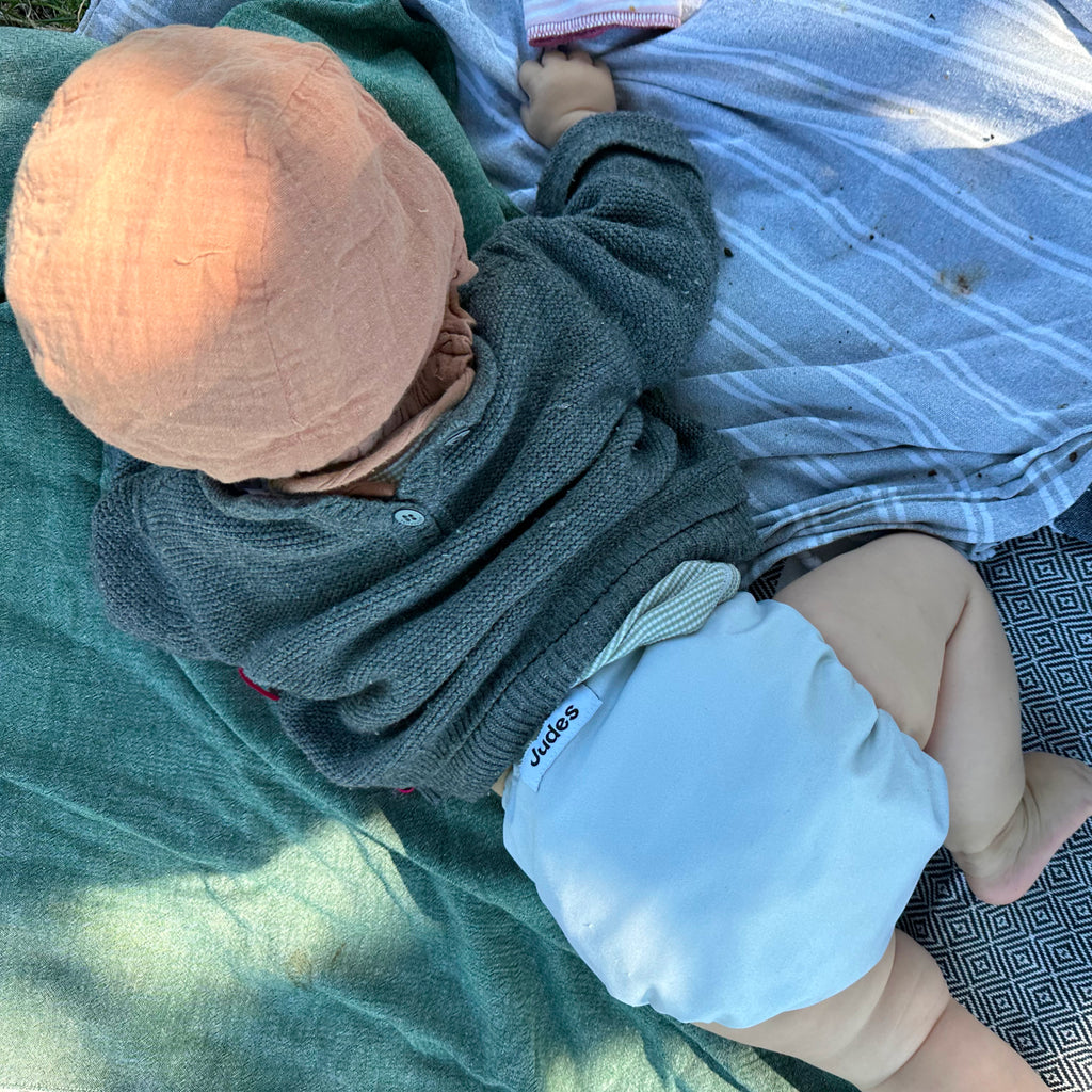 Judes Baby outdoors on blanket hat sweater