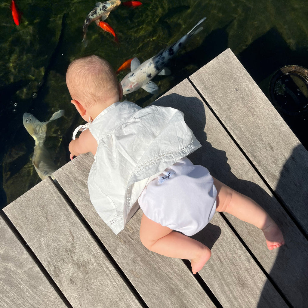 Judes Cuántos pañales vacaciones bebé sobre estanque en muelle