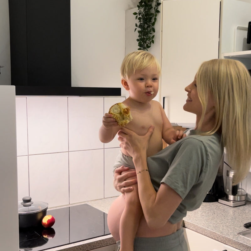 Judes Schwangere mit Baby auf Arm in Küche Ernährung in der Schwangerschaft: Bedeutung für die Entwicklung des Babys