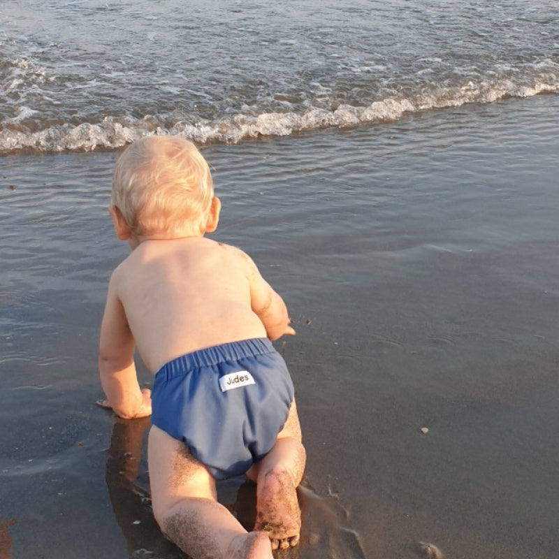 Judes Baby krabbelt am Strand Babyentwicklung mit Stoffwindeln, nachhaltige Windelalternativen