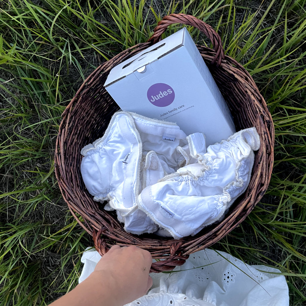 Judes cloth diapers and laundry detergent in basket on grass cloth diapers