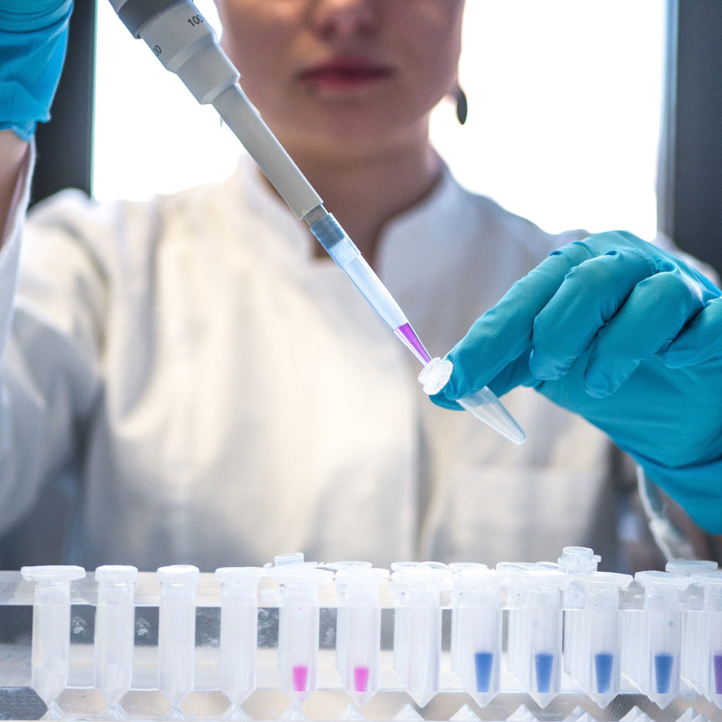 Mujer con guantes de químicos en laboratorio