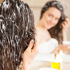 Young woman applying hair mask