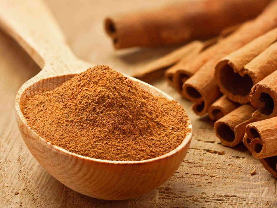 Ground cinnamon with cinnamon sticks next to it