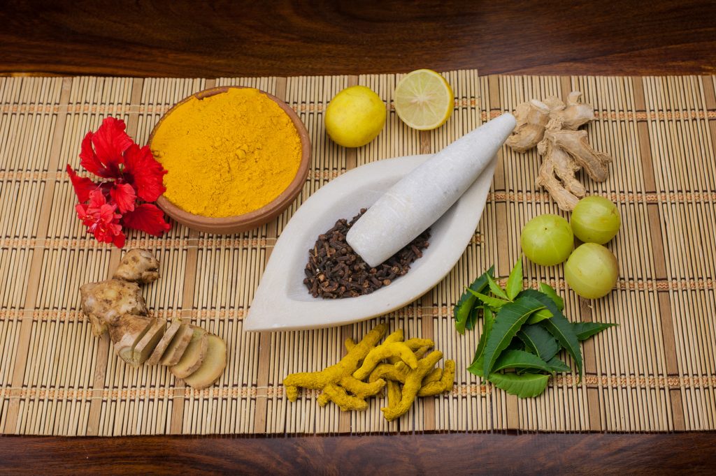 Herbs and spices next to stone bowl