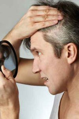 Man looking at grey hair