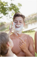 Man getting shaving cream put on his face