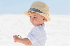 Toddler in sunhat on the beach