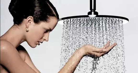 Woman touching shower water