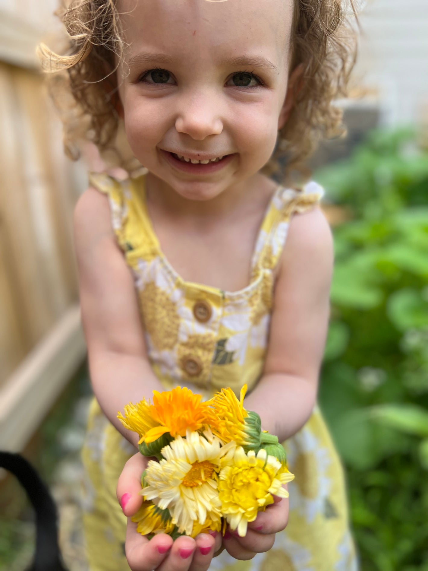 Lyla smiling with some calendula in our garden