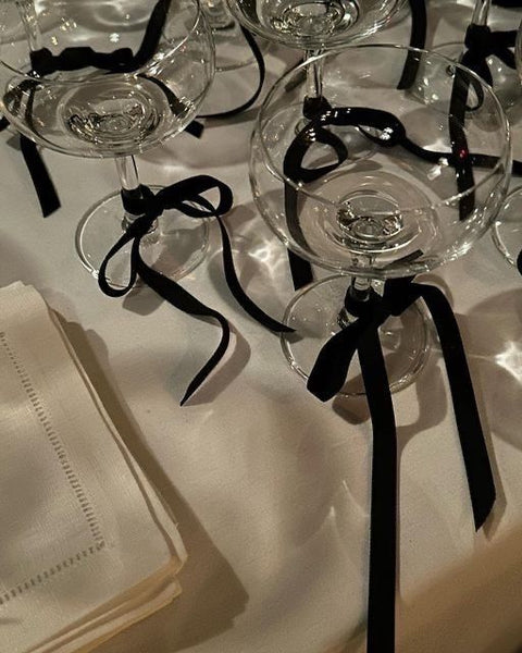 ribbon tied in a bow around cocktail coupe glasses