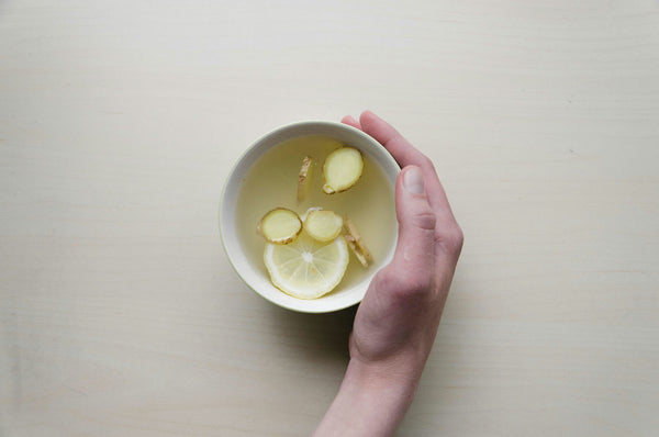 Ginger and Lemon Tea in a Mug with a hand cupping the mug