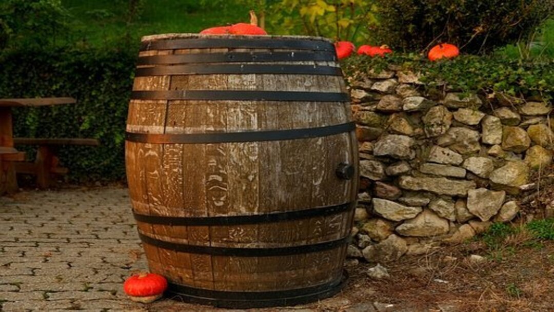 a large brown wine barrel sitting on cobblestones outside