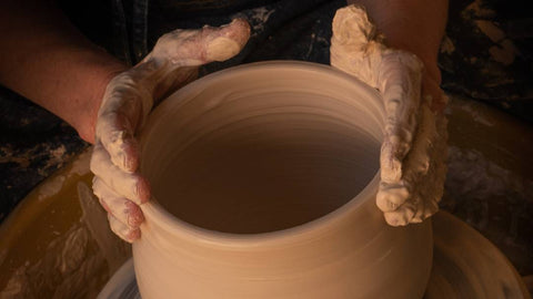 a person making pottery on a wheel