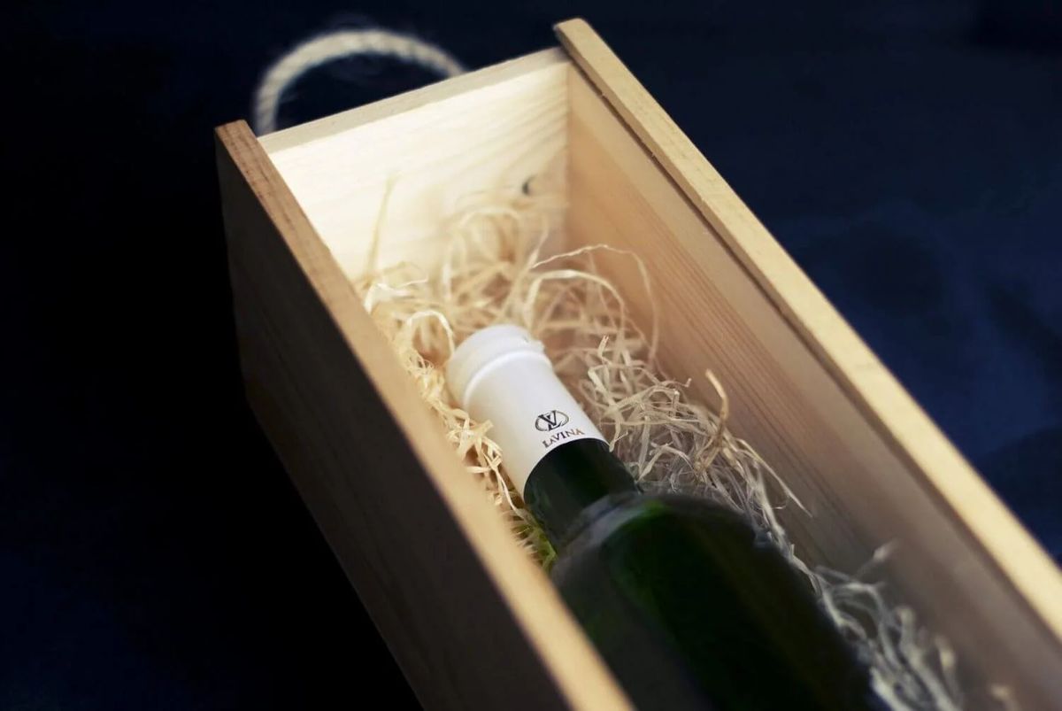 A bottle of wine in a wooden box.