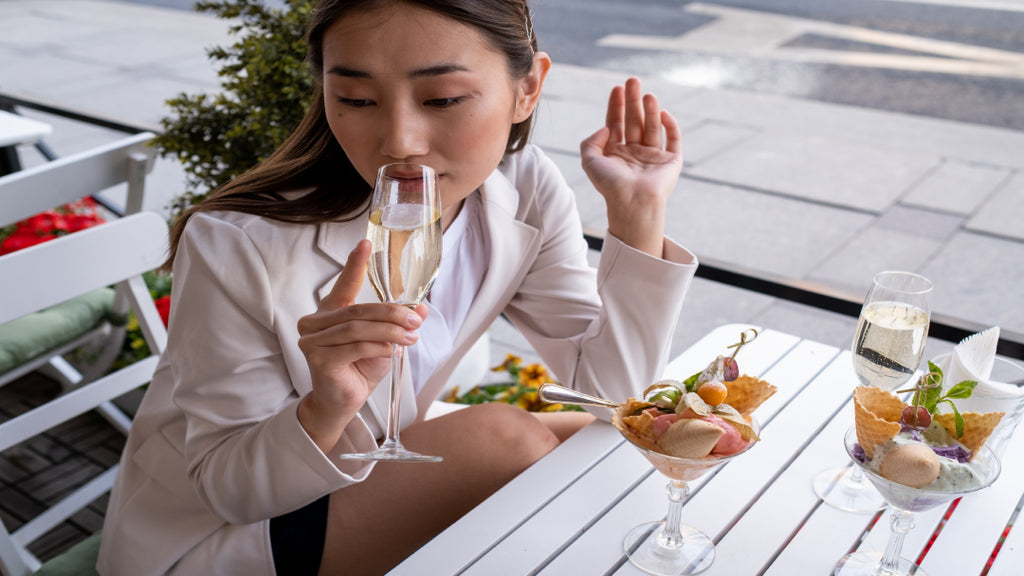 woman drinking white wine with her dessert