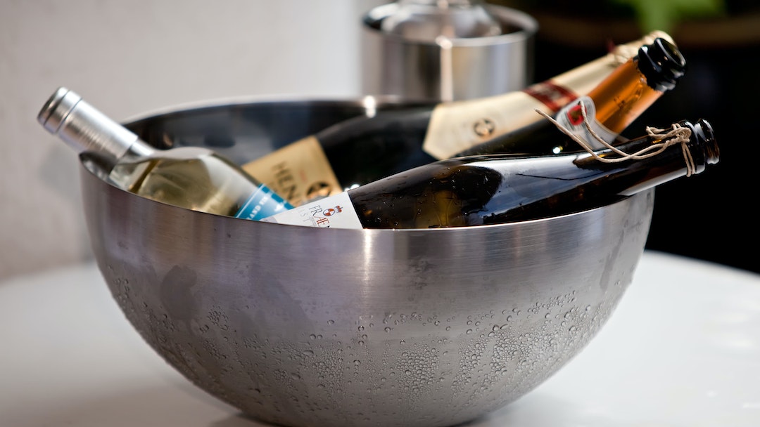 Leftover wine bottles in a round gray stainless steel bowl