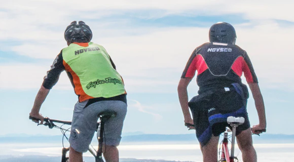 two men riding mountain bikes on top of a mountain 