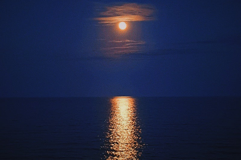 A image of a blue supermoon above the ocean
