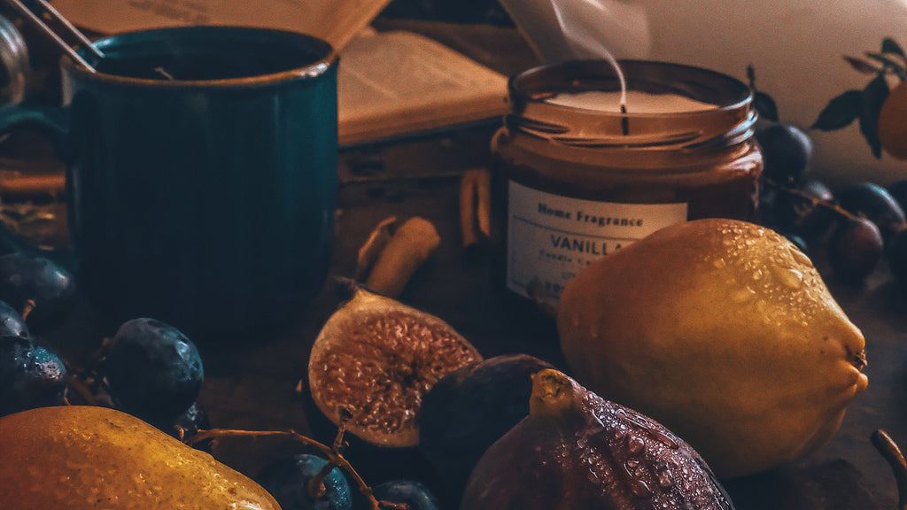An image of lemons, figs, tea, and a vanilla scented candle on a countertop.