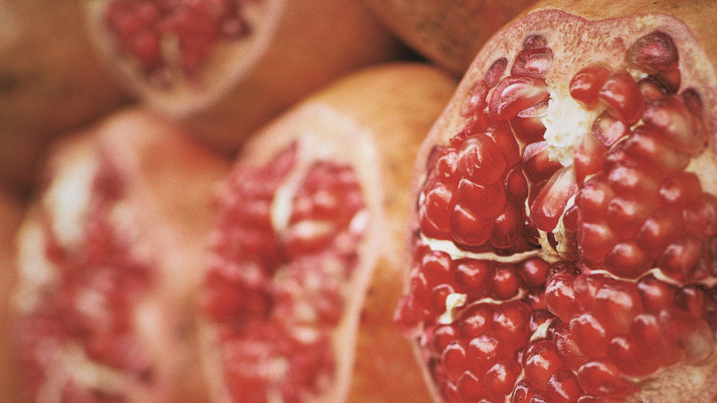 Close-up of pomegranate halves revealing their rich, ruby-red seeds, evoking the deep, vibrant hues of the Full Blood Moon, symbolically linked with the fertile and sensual characteristics of Taurus.