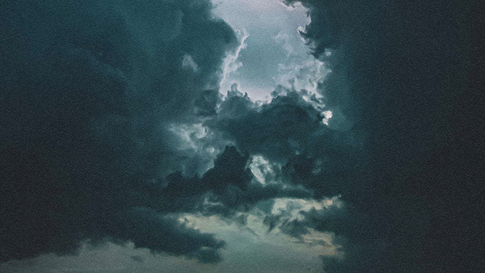 Dramatic image of stormy clouds with a hidden moon, capturing the unpredictable energy of Uranus during the new moon.