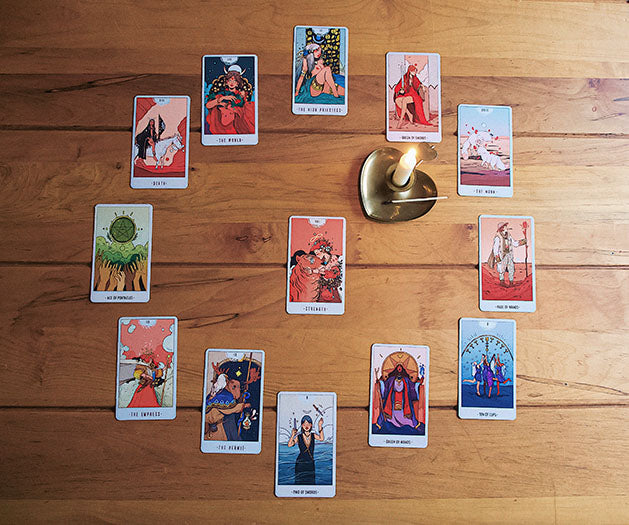 An overhead view of a complete New Year's Tarot Spread on a rustic wooden table, with cards artistically arranged to forecast the upcoming year's journey.