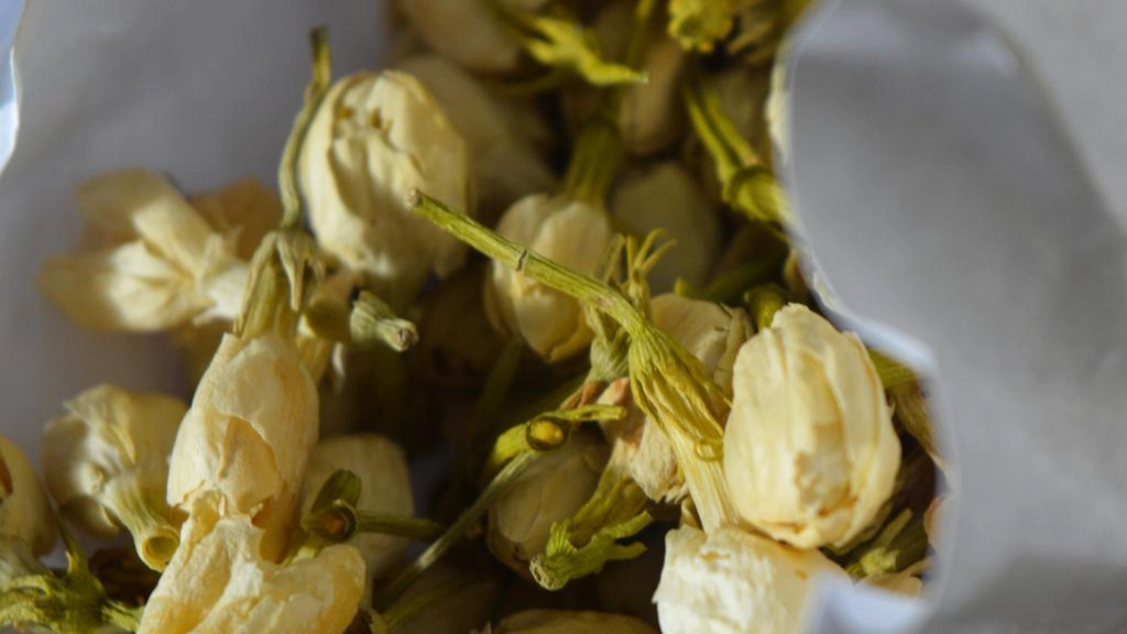 Close-up of dried jasmine flowers in a bag, suggesting the theme of purification and preparation for spring, which aligns with the Snow Moon's significance.