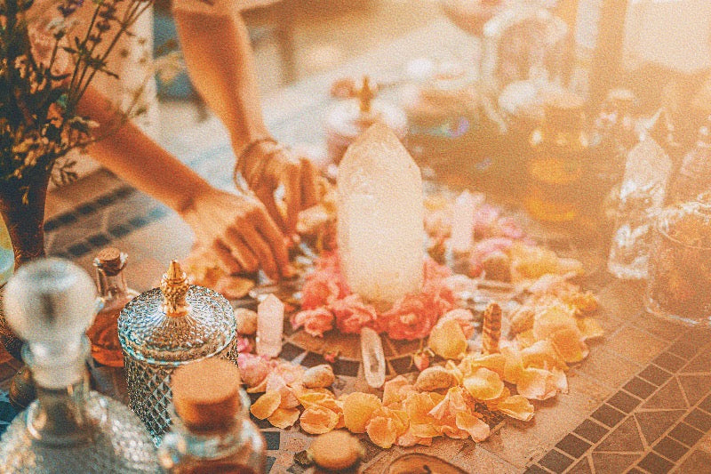 A person setting up a crystal grid in an apothecary-style setting, showcasing one of the many manifestation techniques explained in the blog post, symbolizing the intentional arrangement of crystals to amplify manifestation energies.