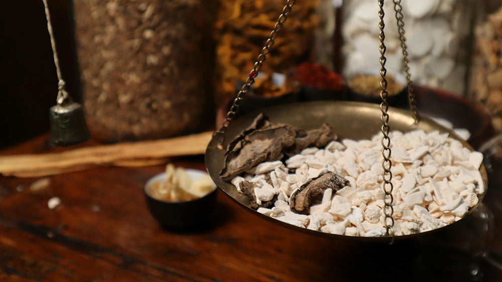 A rustic scale with a brass pan filled with white and gray stones, evoking a sense of balance and natural elements.