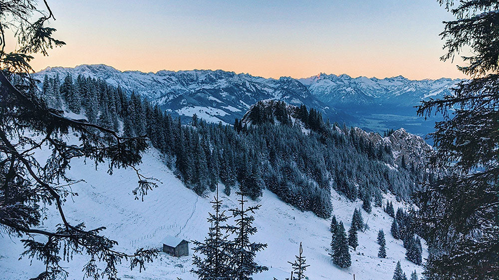 A breathtaking landscape of snowy mountains under a clear sky, representing the lofty heights and enduring nature of Capricorn during the New Wolf Moon.