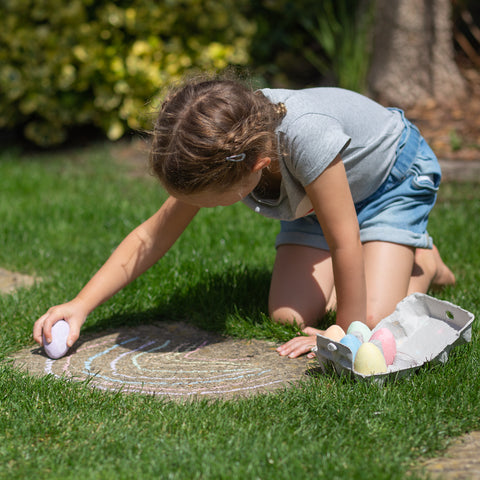 Easter toys: girl drawing with Chalk Eggs