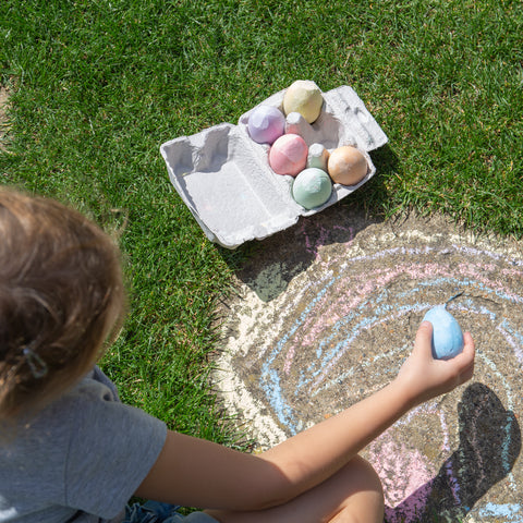 Girl drawing with Chalk Eggs outside
