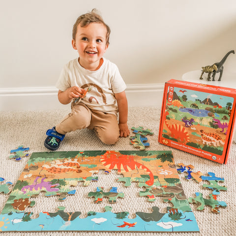Boy completing our wooden dinosaur floor puzzle