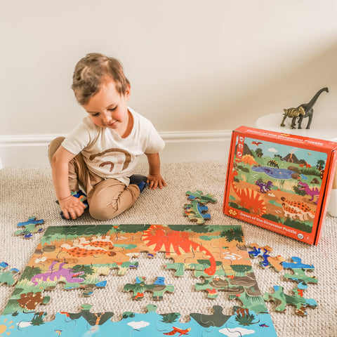 Boy playing with Dawn of the Dinosaur Floor Puzzle