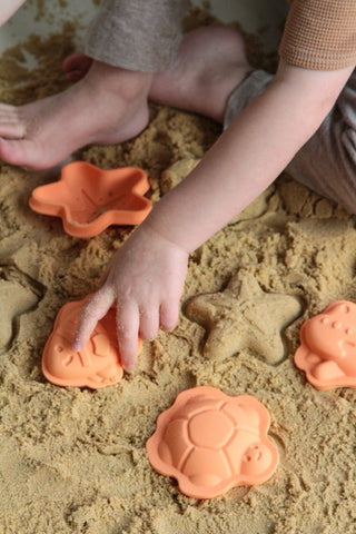 Child playing with Character Sand Moulds sand toy