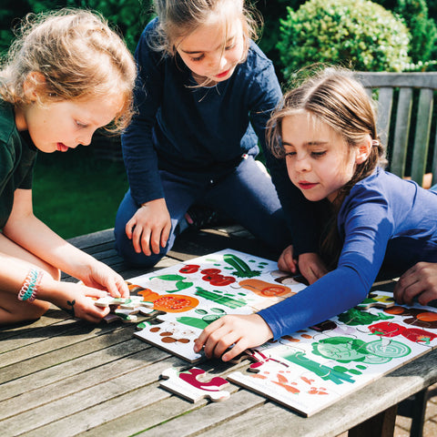 Unplugged play: children piecing together a floor puzzle