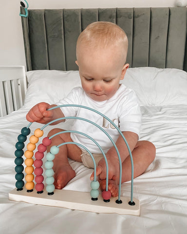 Baby playing with Rainbow Abacus