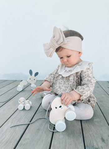 Toddler playing with wooden push along toys