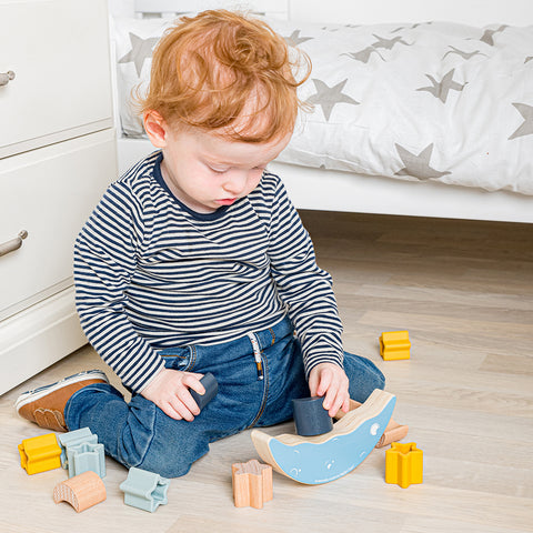 Boy playing with Moon Balance Stacker wood & silicone toy