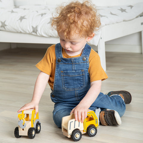 Boy playing with mini toy trucks