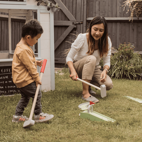 Mum and child playing Crazy Golf in garden